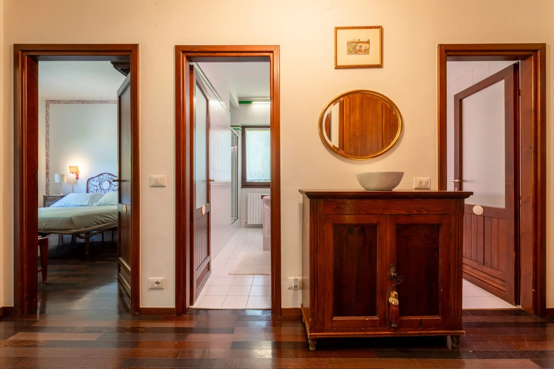 A hallway with dark wooden furniture and open doorways.