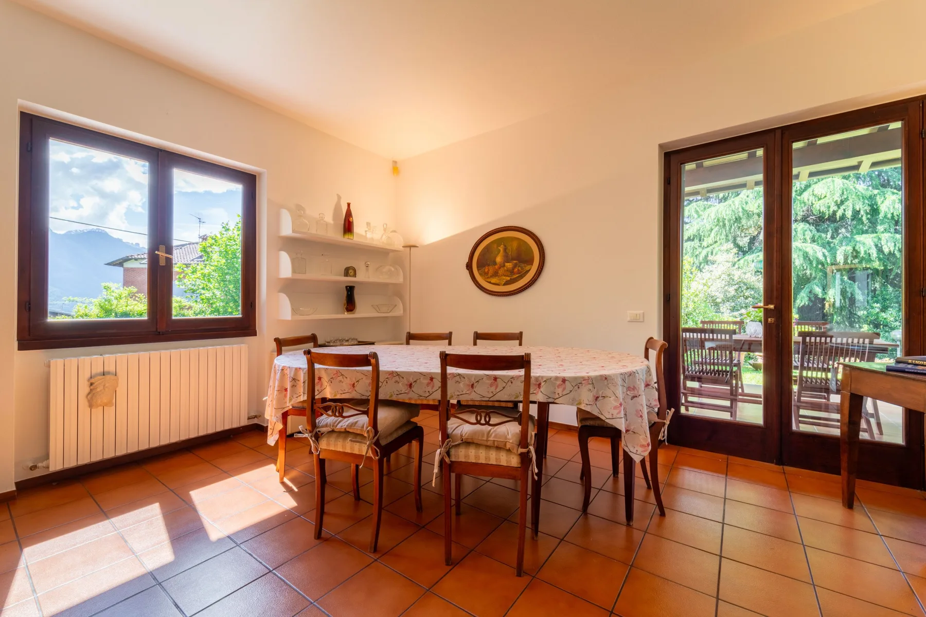A dining area with a table and chairs beside windows and glass doors.