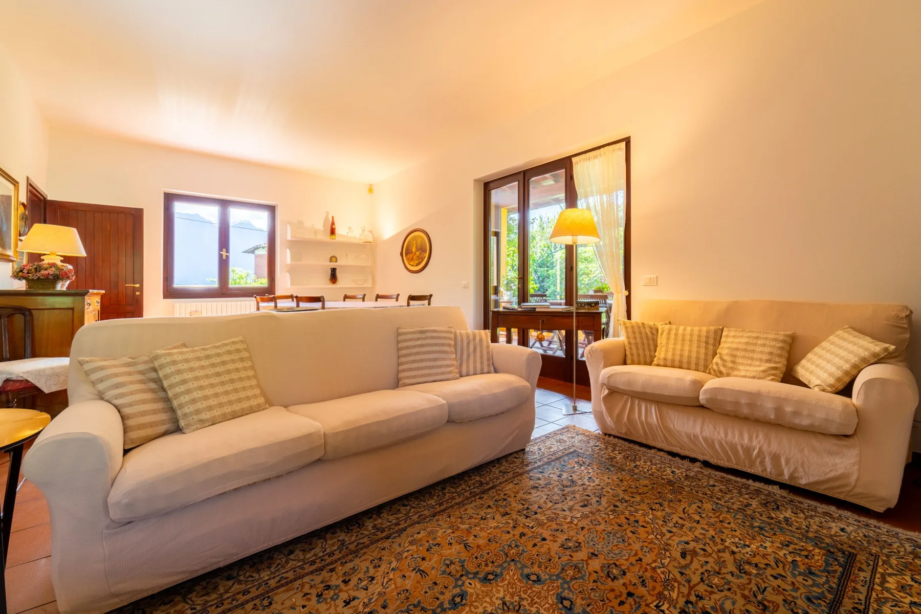 A living room with two seating areas and a patterned rug.
