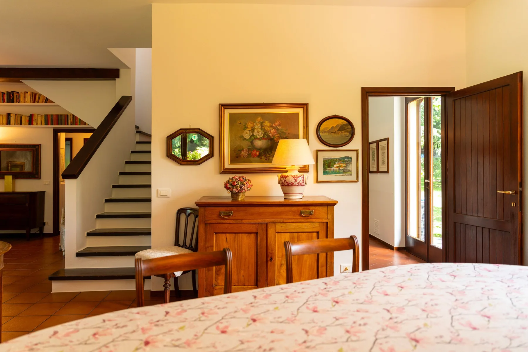 A bedroom with a wooden dresser and an open doorway beside the bed.