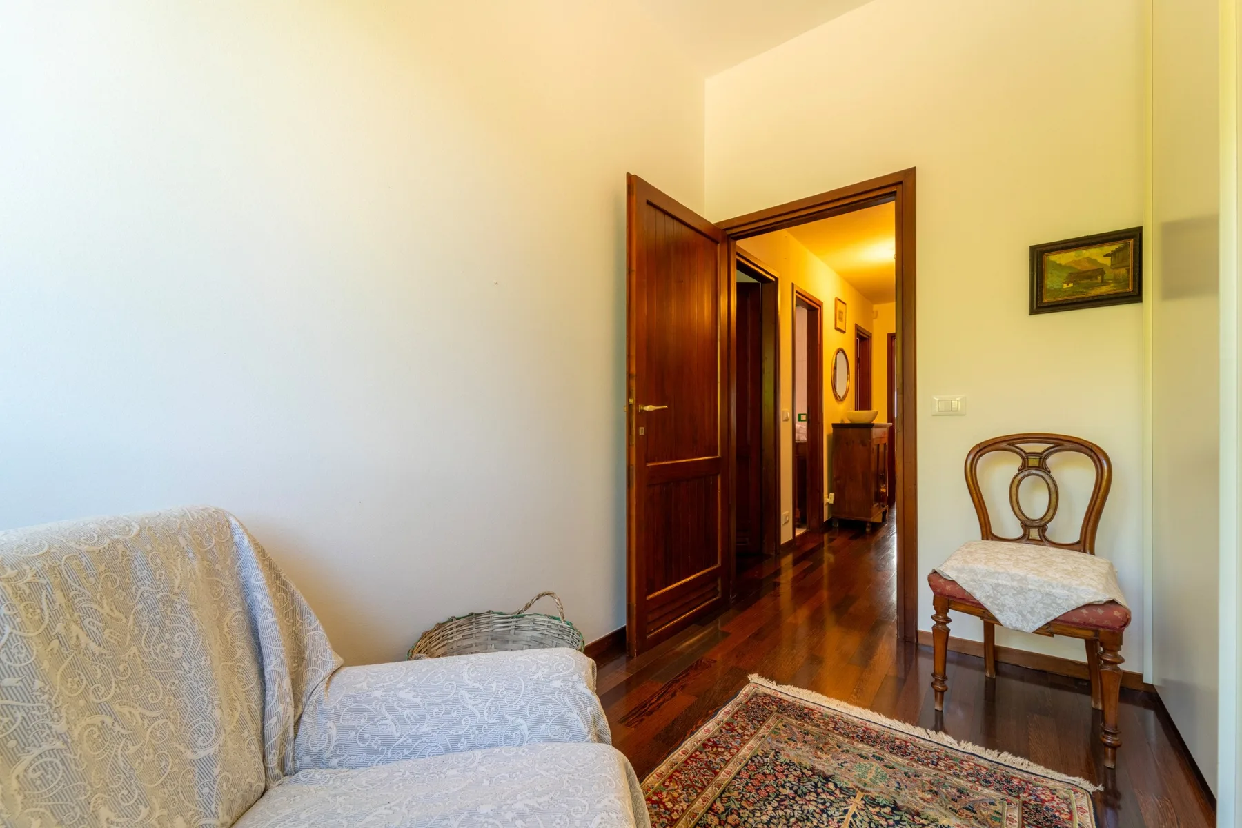 A living room with seating beside an open doorway to a hallway.