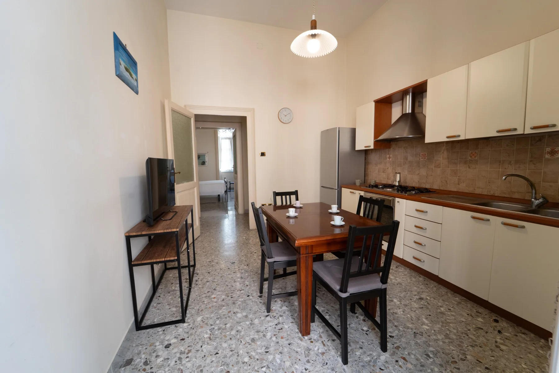 A dining area with a wooden table beside a kitchen.