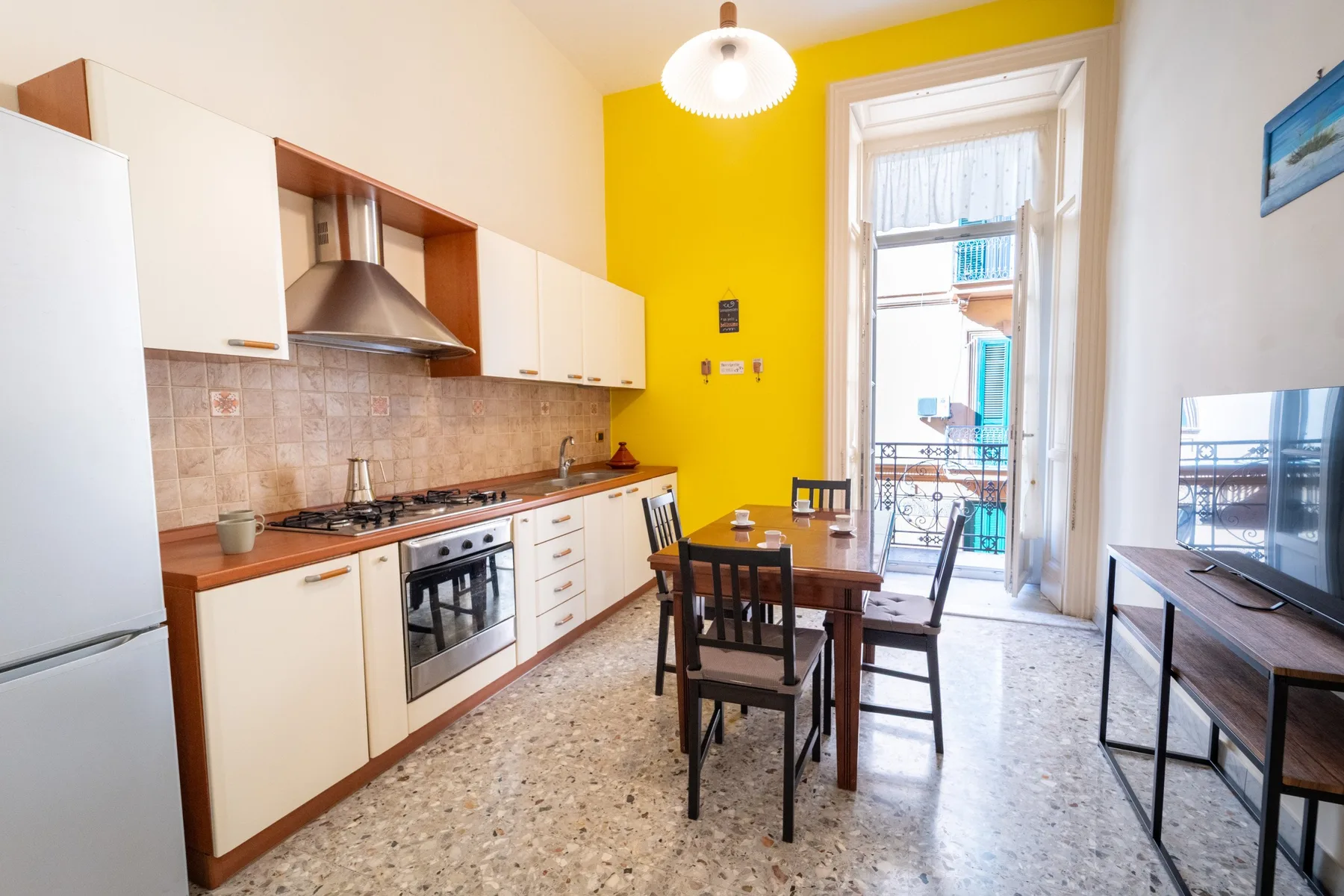 A kitchen dining area with a table beside a tall window.