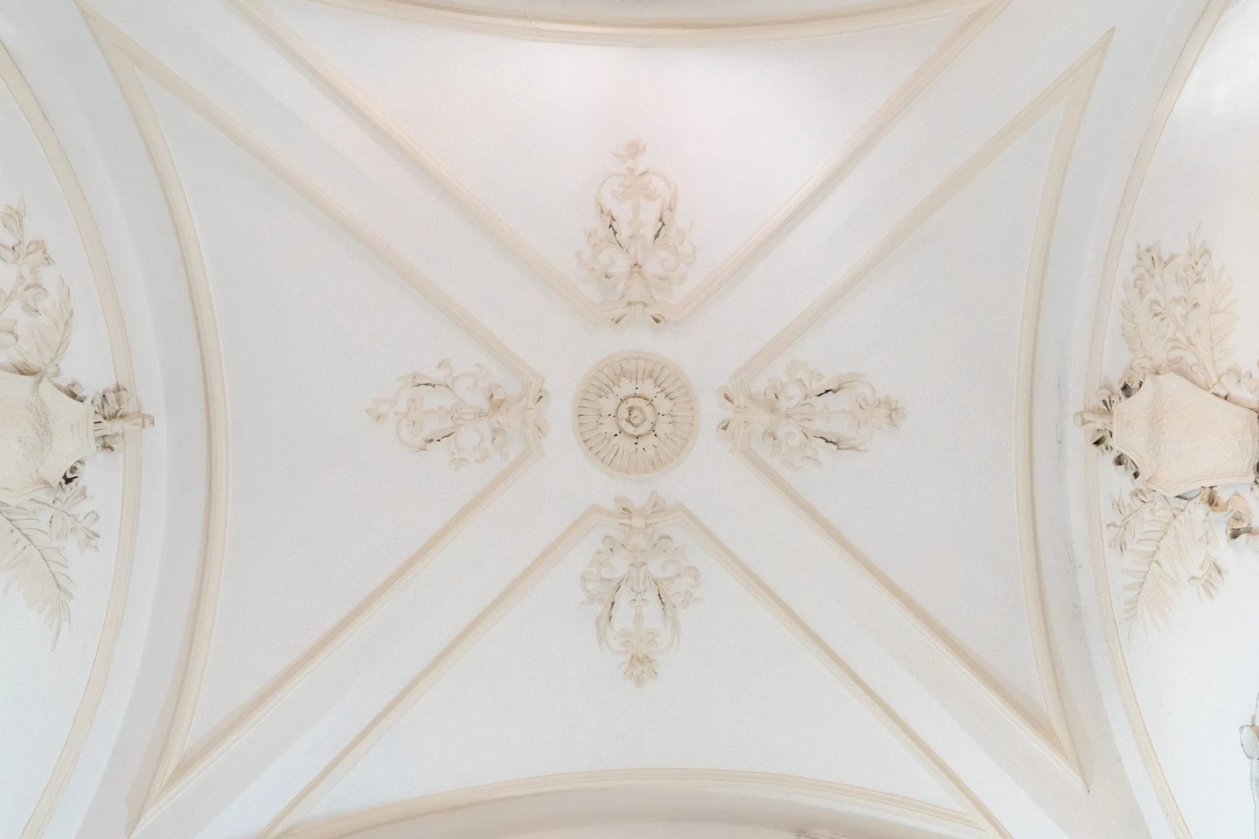 An ornate ceiling features decorative plasterwork and a central medallion.