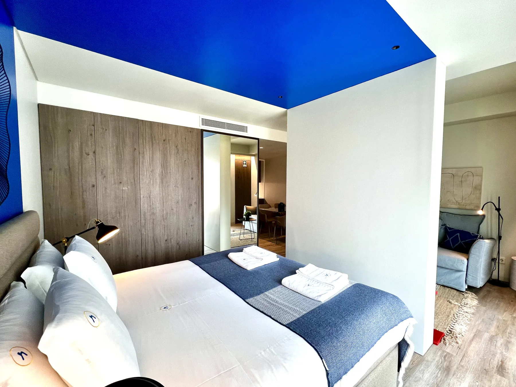 Un dormitorio con una cama bien hecha y techo azul.
