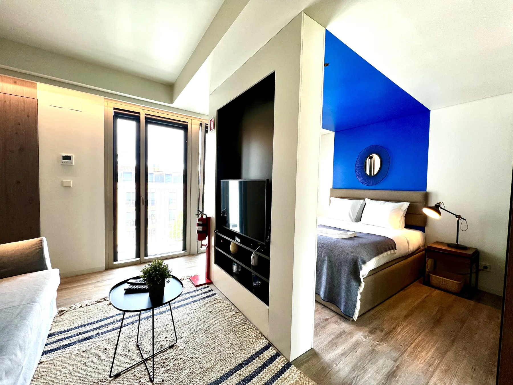 Un estudio con una cama, asientos y una zona de televisión.
