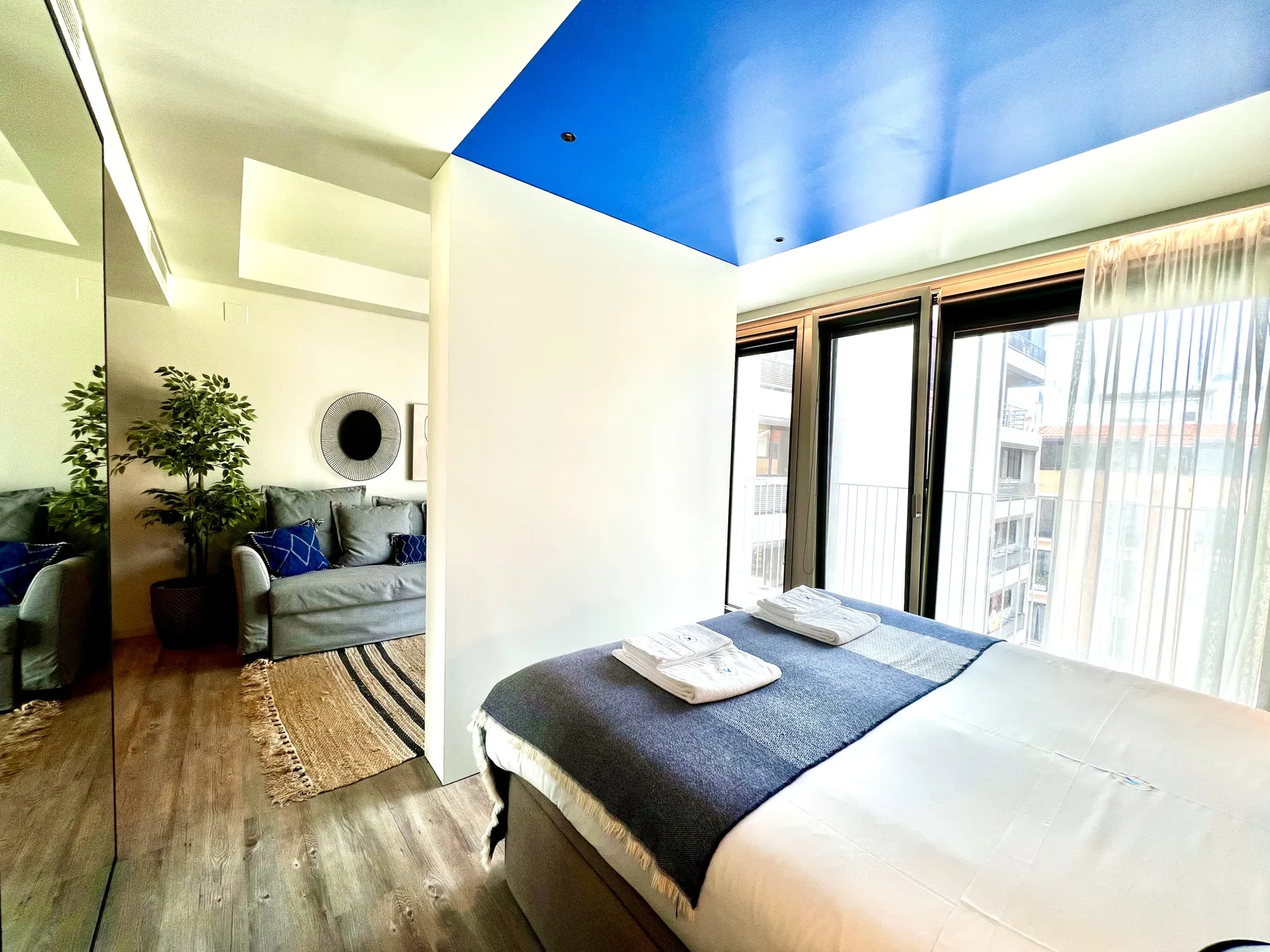 Un dormitorio con una cama arreglada junto a una zona de estar.