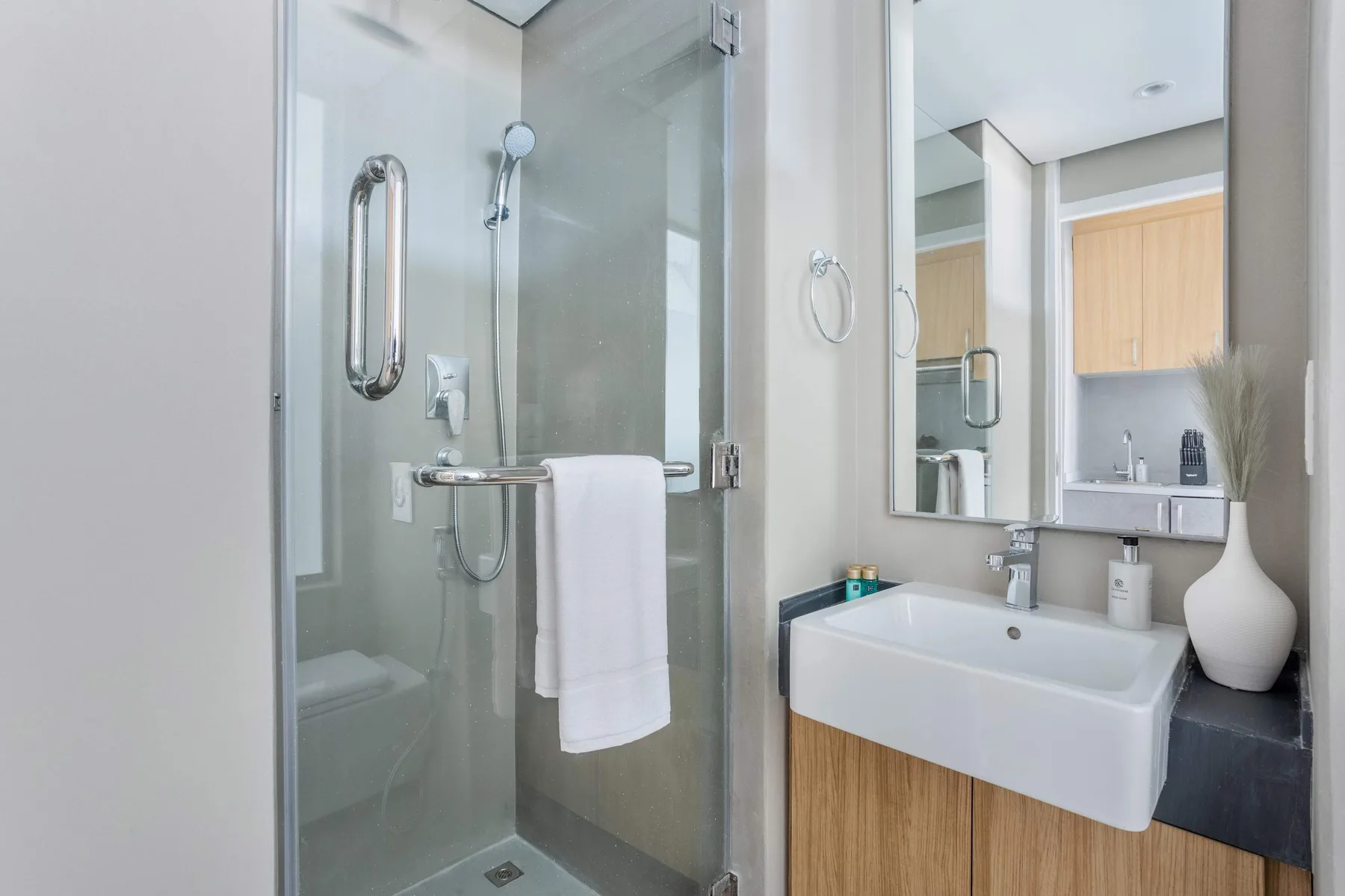 A modern bathroom with a glass shower and a sink beneath a mirror.