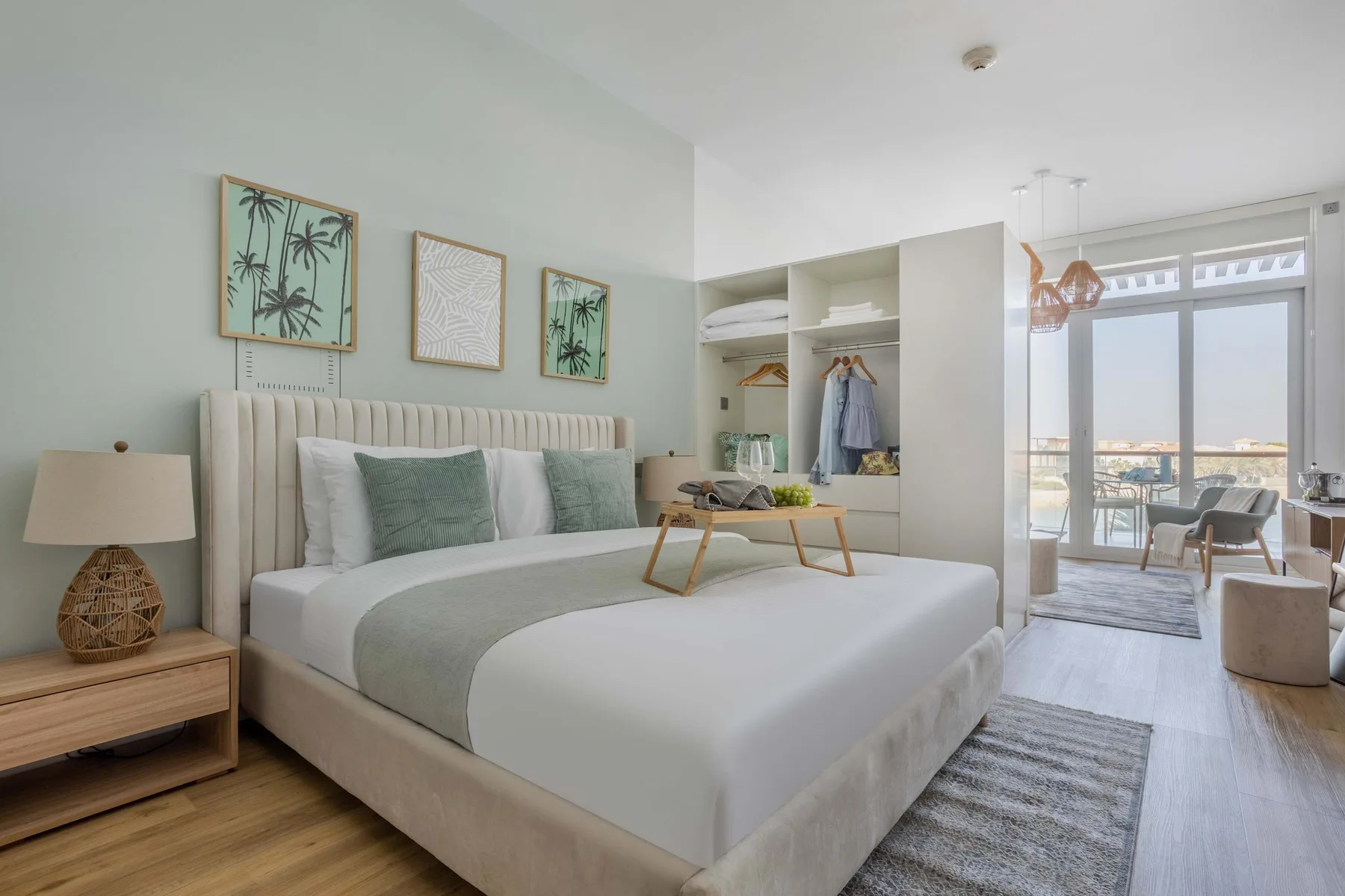 Bedroom with a neatly made bed, bedside tables, and an open wardrobe.