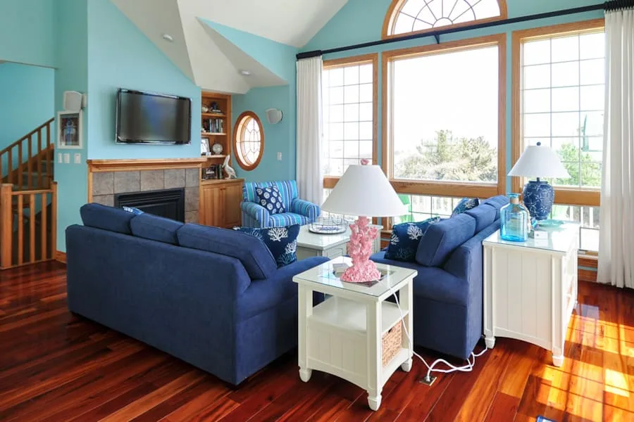 Una sala luminosa con asientos azules y ventanas grandes.