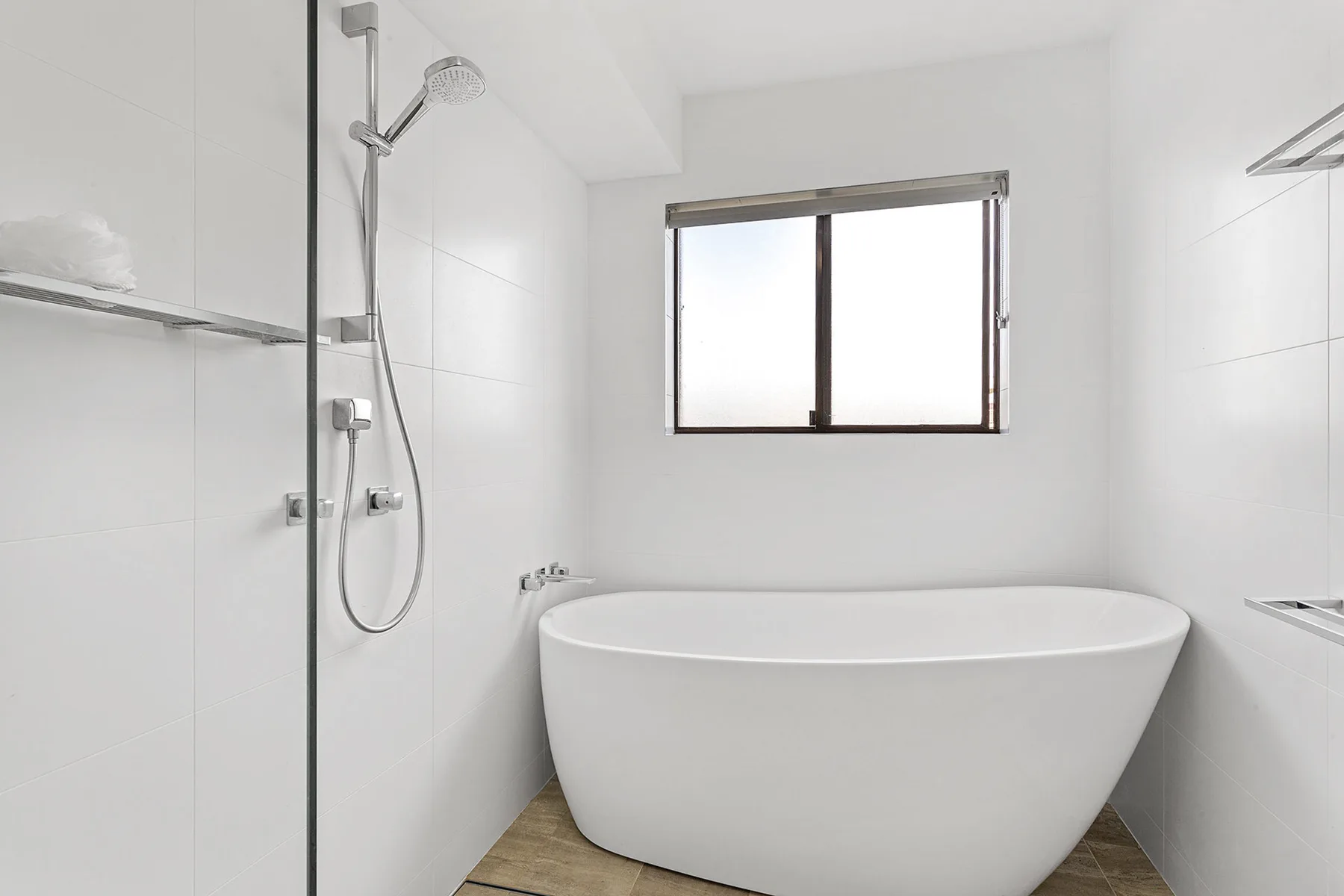 Un baño luminoso con bañera exenta y ducha.
