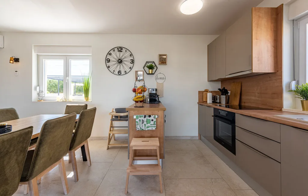 A bright kitchen and dining area with a central counter and windows.