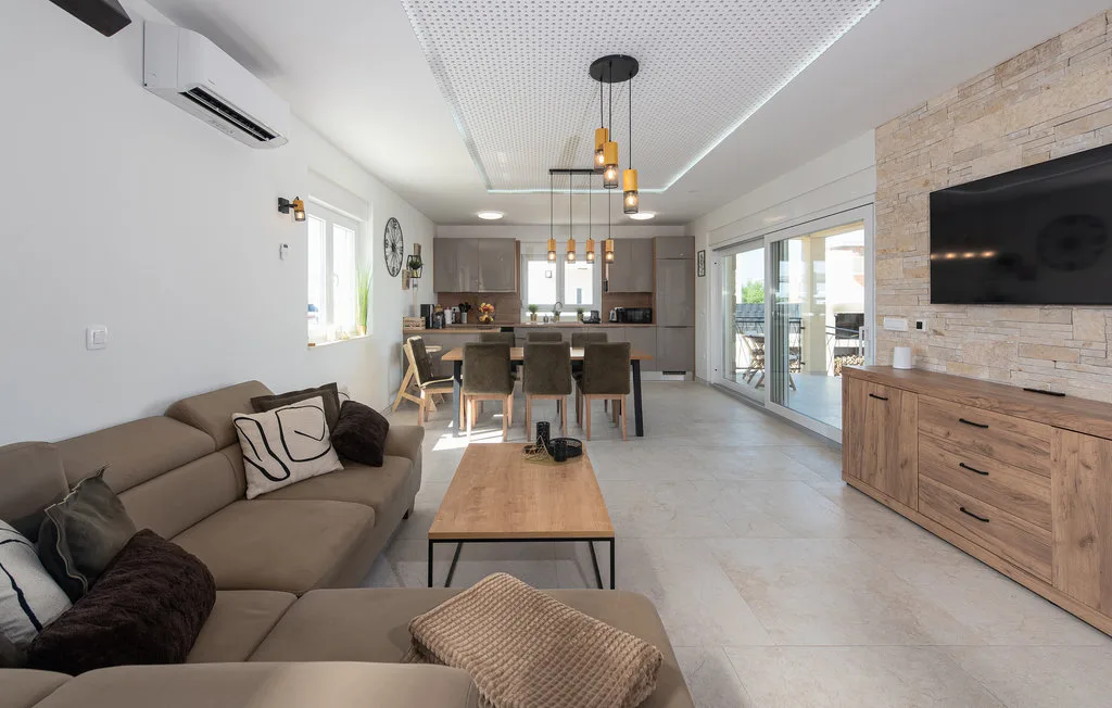 Una sala-comedor de concepto abierto tiene asientos, una mesa de comedor y un televisor.