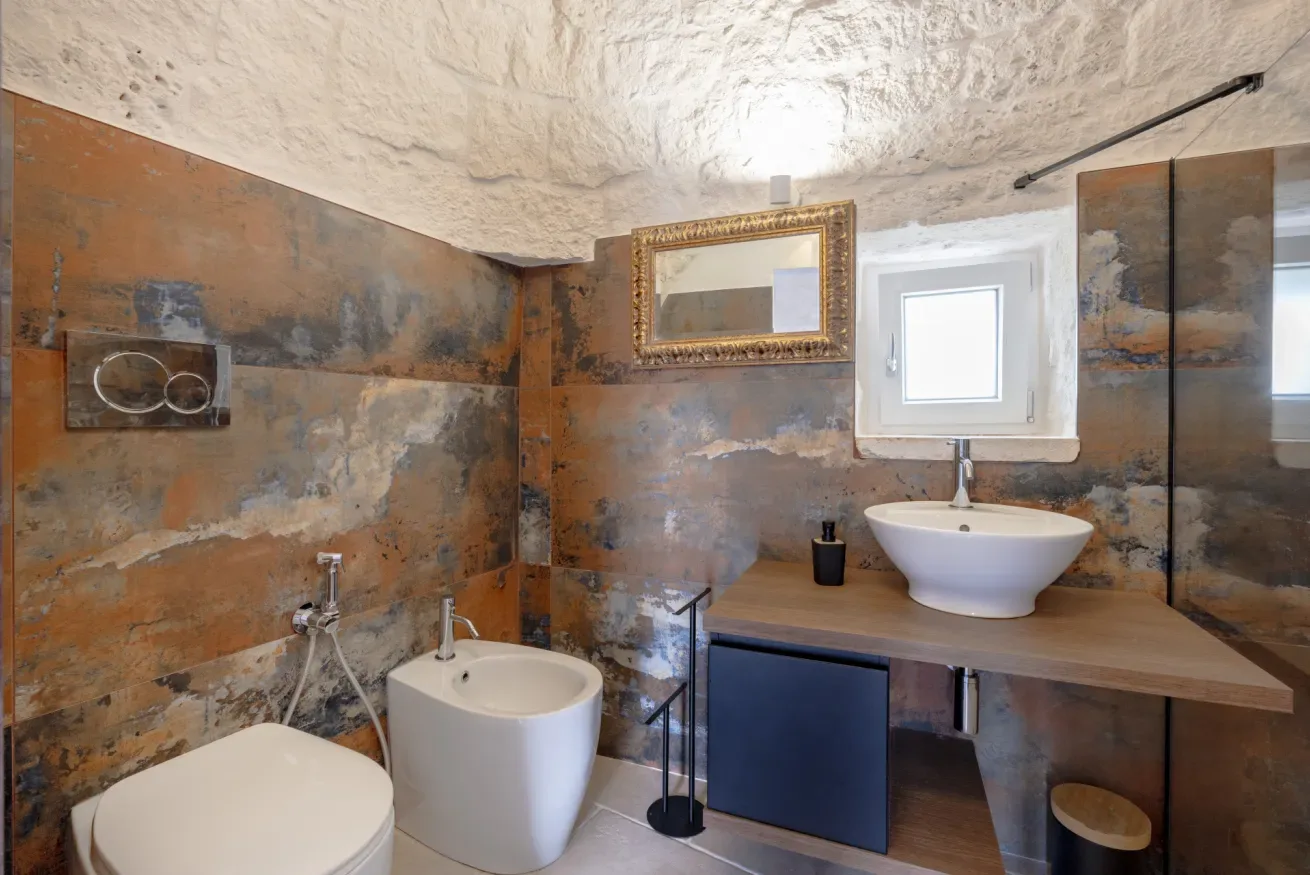 A bathroom with a sink, toilet, and shower fixtures.