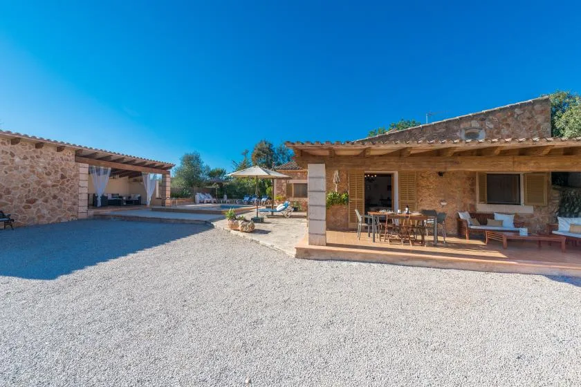 A stone courtyard with a covered patio and outdoor seating.