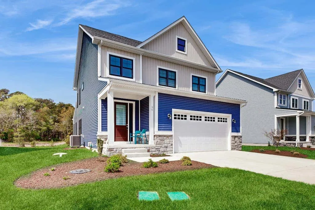 A two-story suburban house with a blue garage door and front lawn.