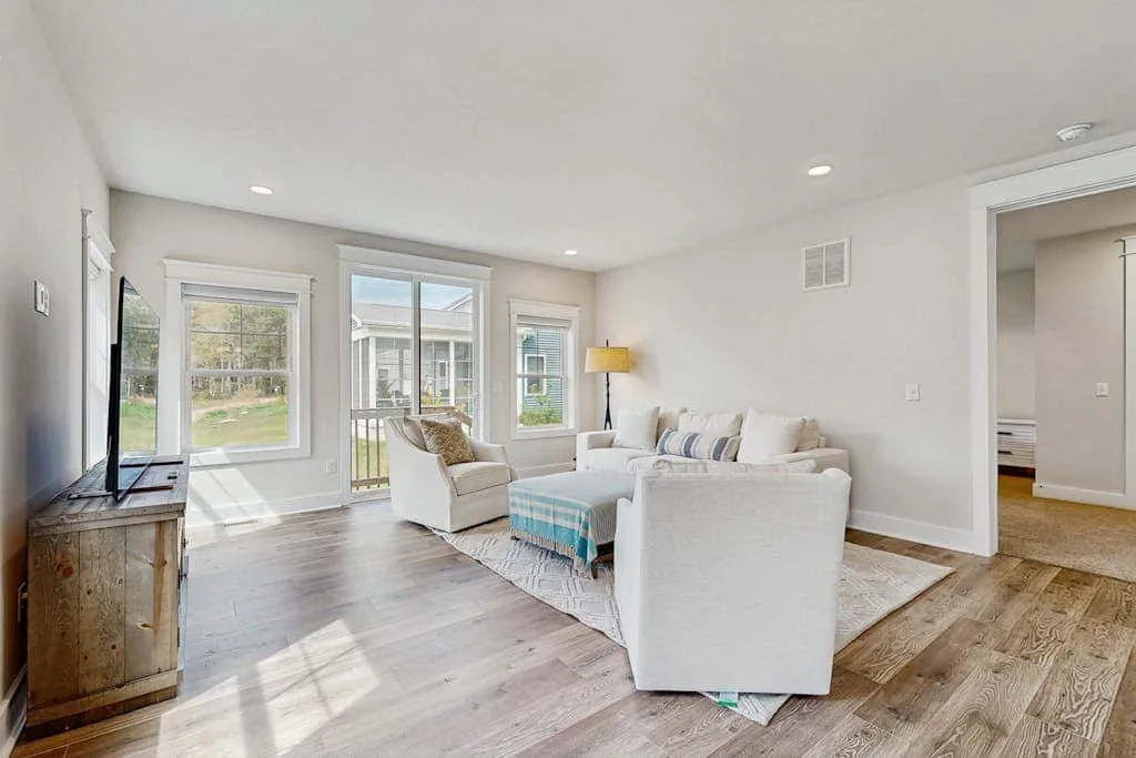 A bright living room with seating arranged around a coffee table.