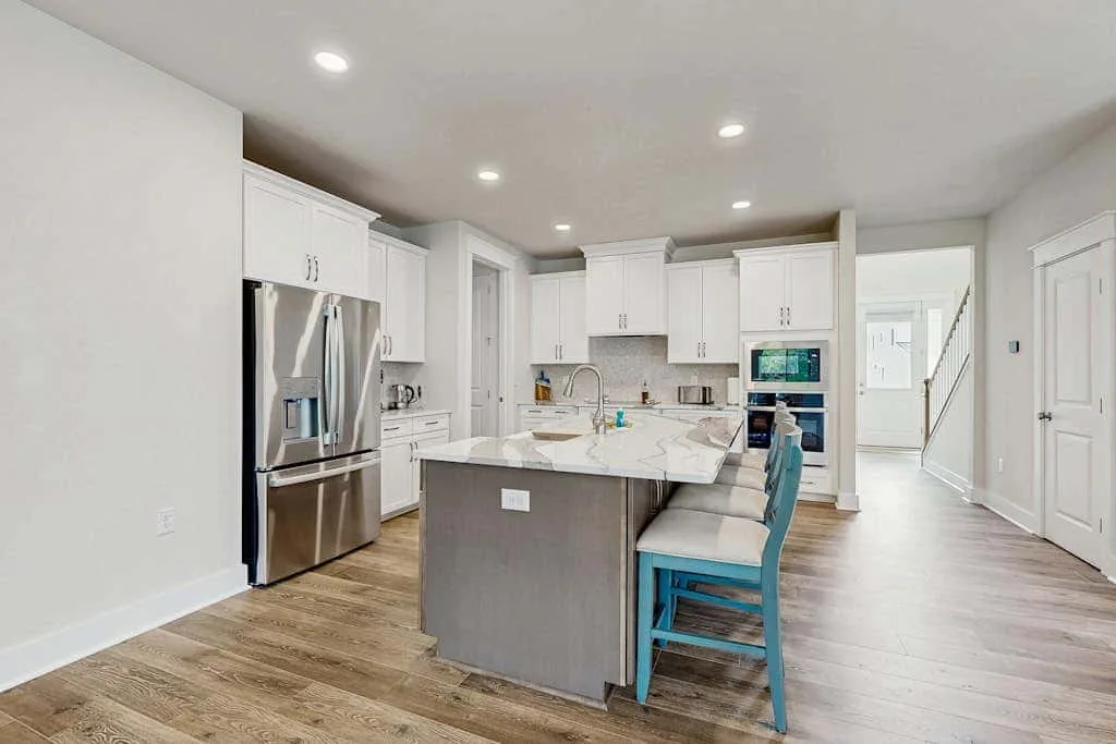 A bright open kitchen with a central island and stainless steel appliances.