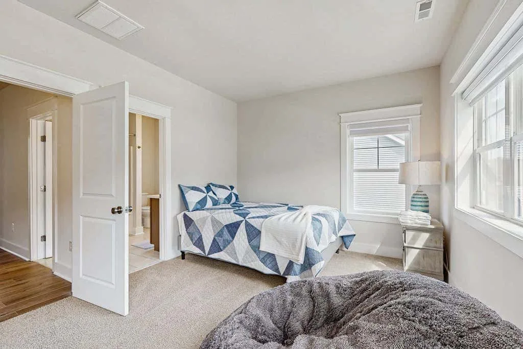 Bedroom with a bed covered in blue and white geometric bedding.