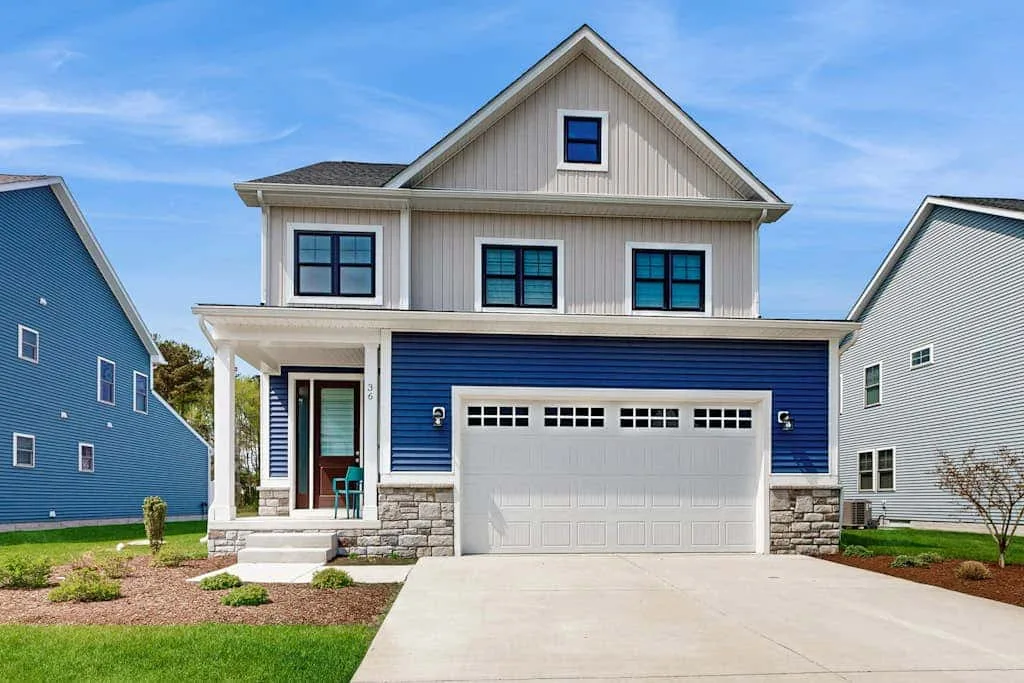 A two-story house with a front porch and attached garage.
