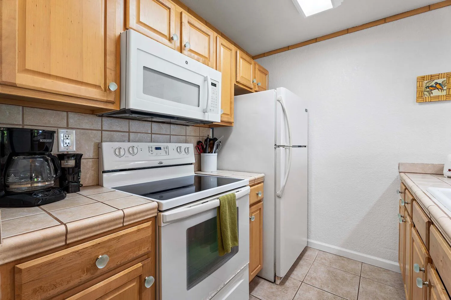 Una cocina compacta con gabinetes de madera, una estufa y un refrigerador.