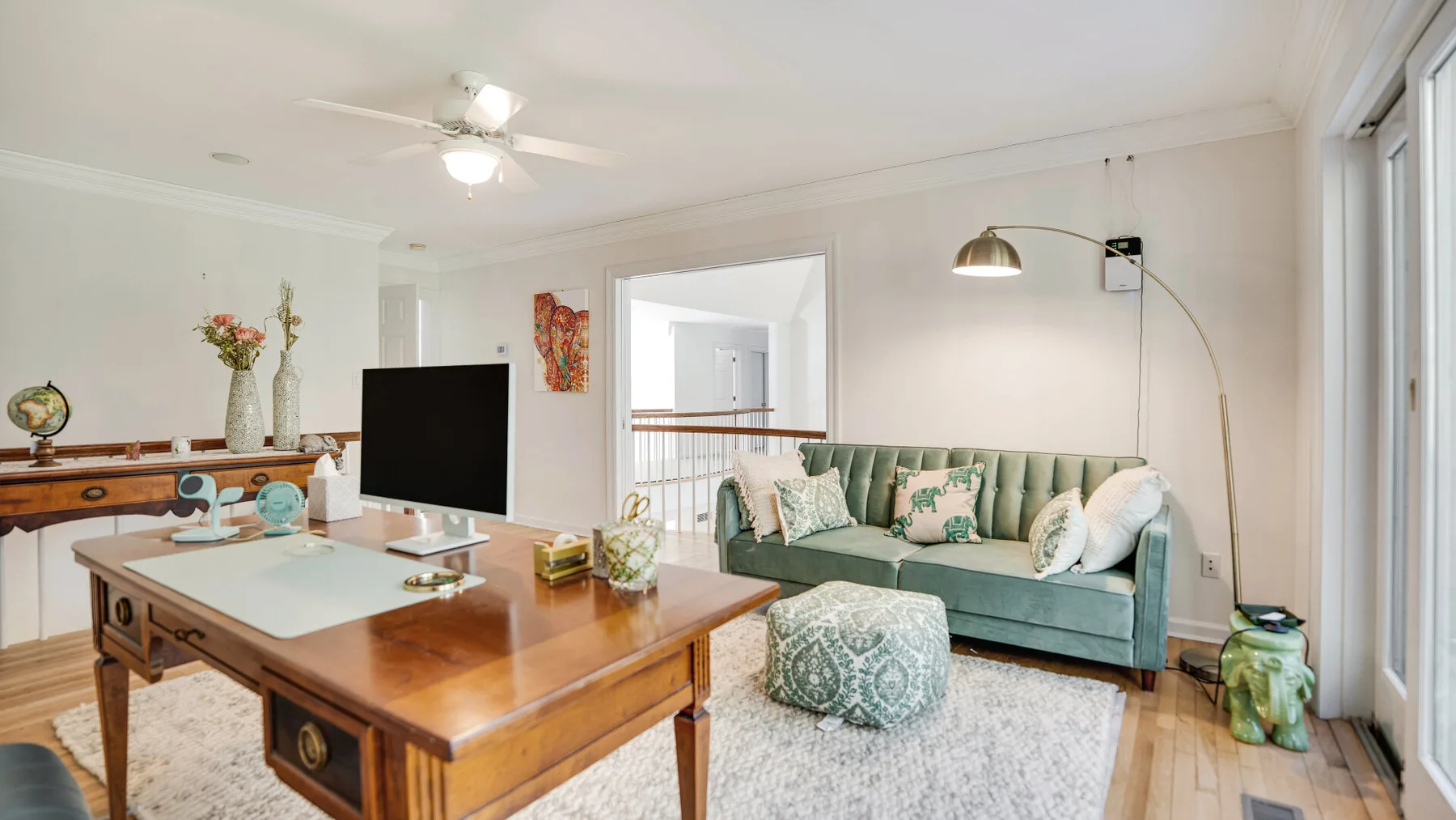 A bright living room with a wooden table and green seating.
