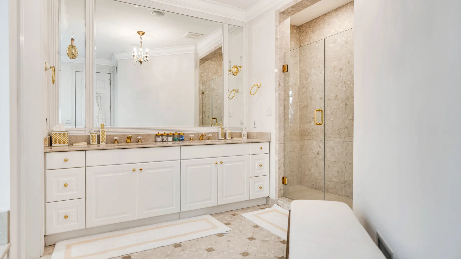 A bright bathroom with a long vanity and a glass shower.