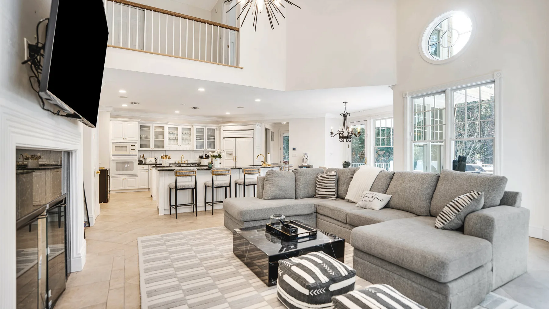 A bright open-plan living room with a sectional seating area and kitchen.