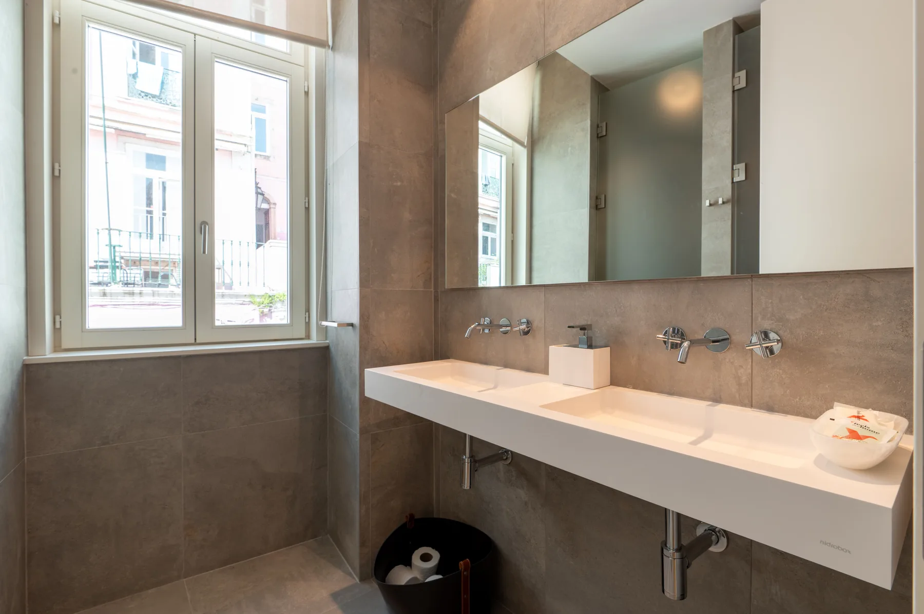 A bathroom with a wide sink counter beneath a large mirror.