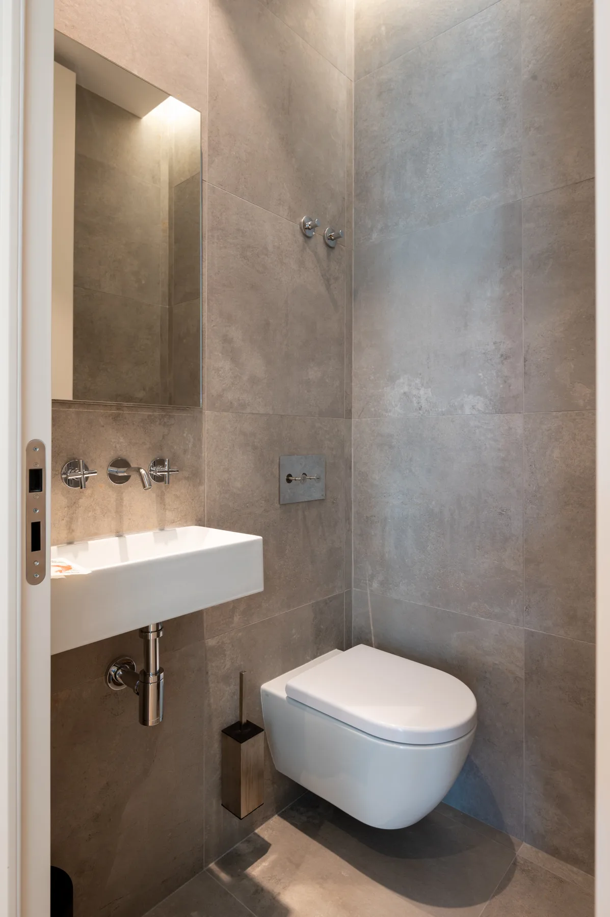 A compact bathroom with a wall-mounted sink and toilet.