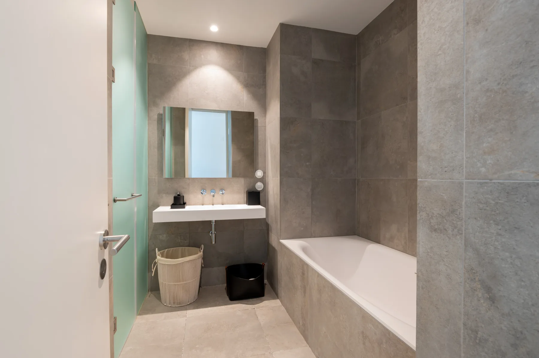 A modern bathroom with a bathtub and sink.