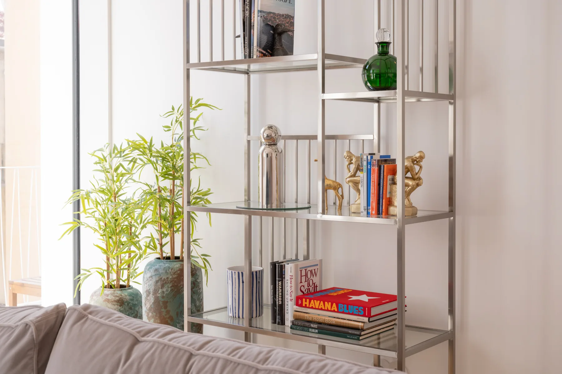 A living room seating area sits beside an open shelving unit with books and decor.