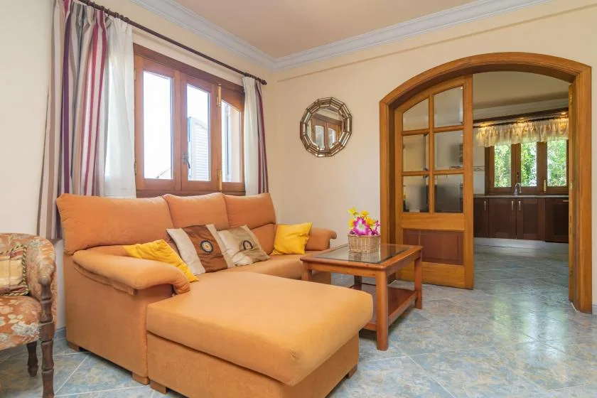 Una sala de estar con un sofá seccional y una mesa de centro de madera junto a un arco.
