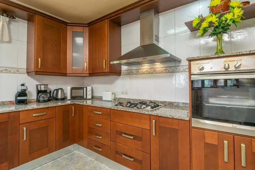 Una cocina con gabinetes de madera, una encimera y electrodomésticos.
