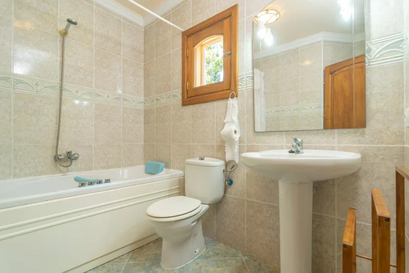 Un baño alicatado con bañera y lavabo con pedestal.