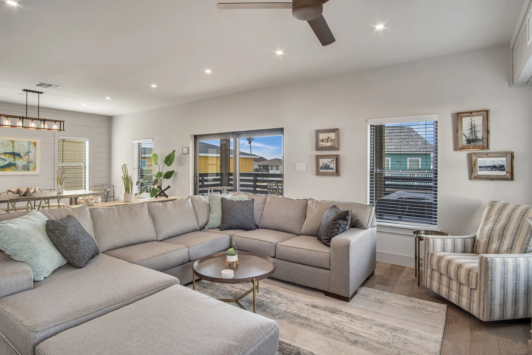 A bright living room with sectional seating and a round coffee table.