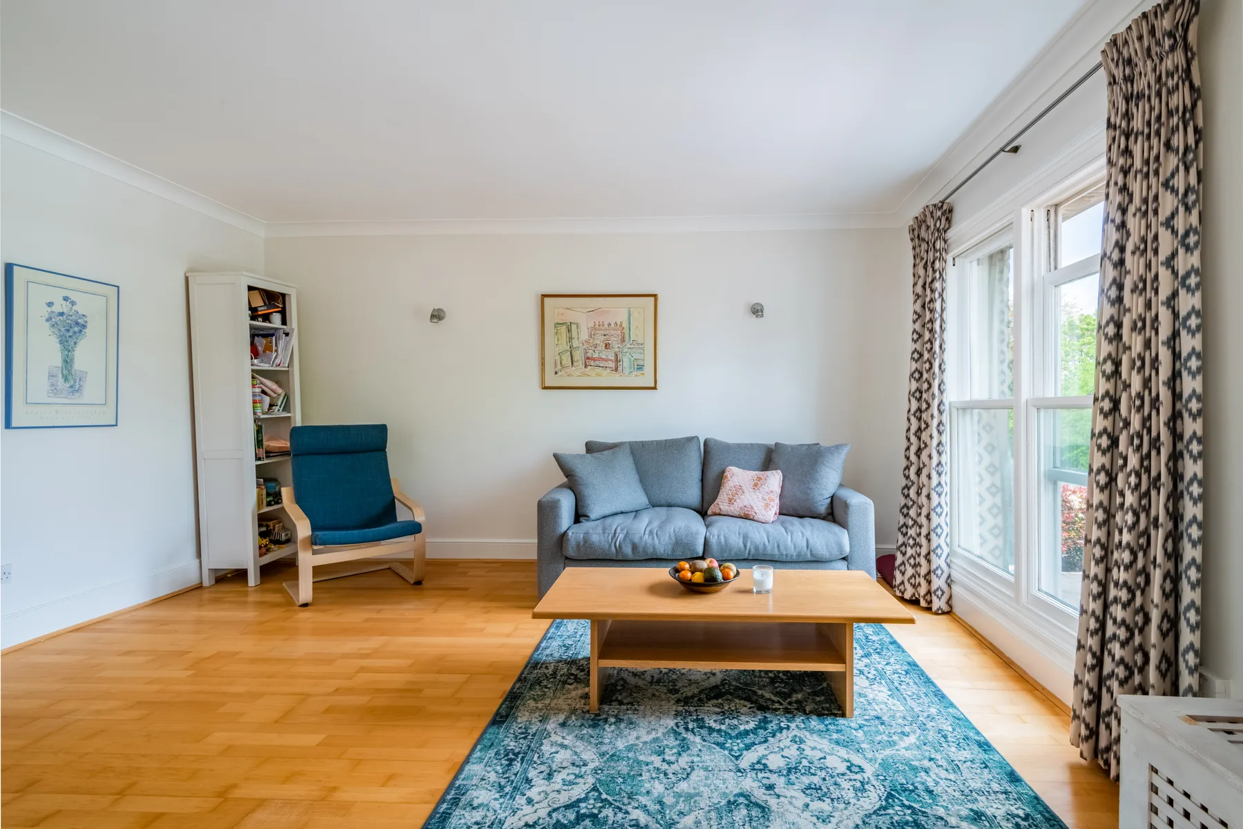 A bright living room with a blue sofa and a wooden coffee table.