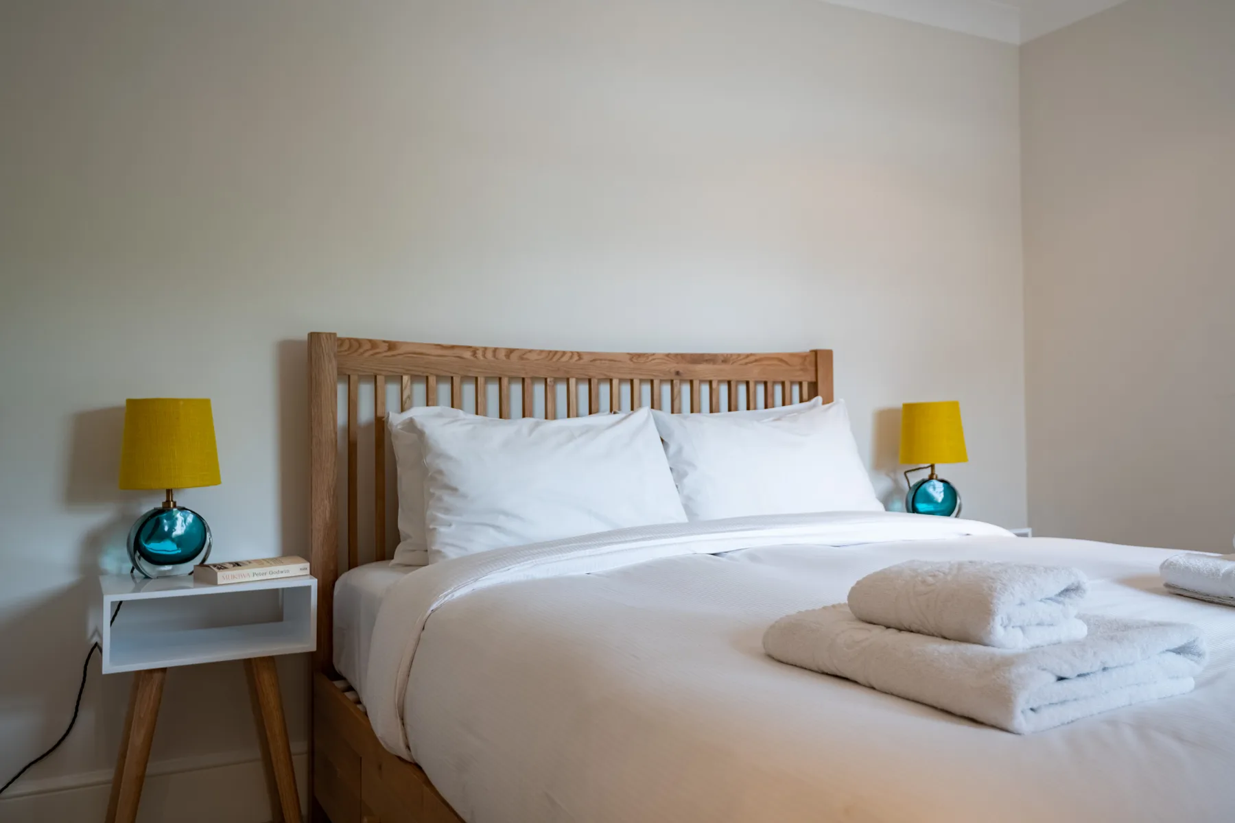 Bedroom with a wooden bed and white bedding.