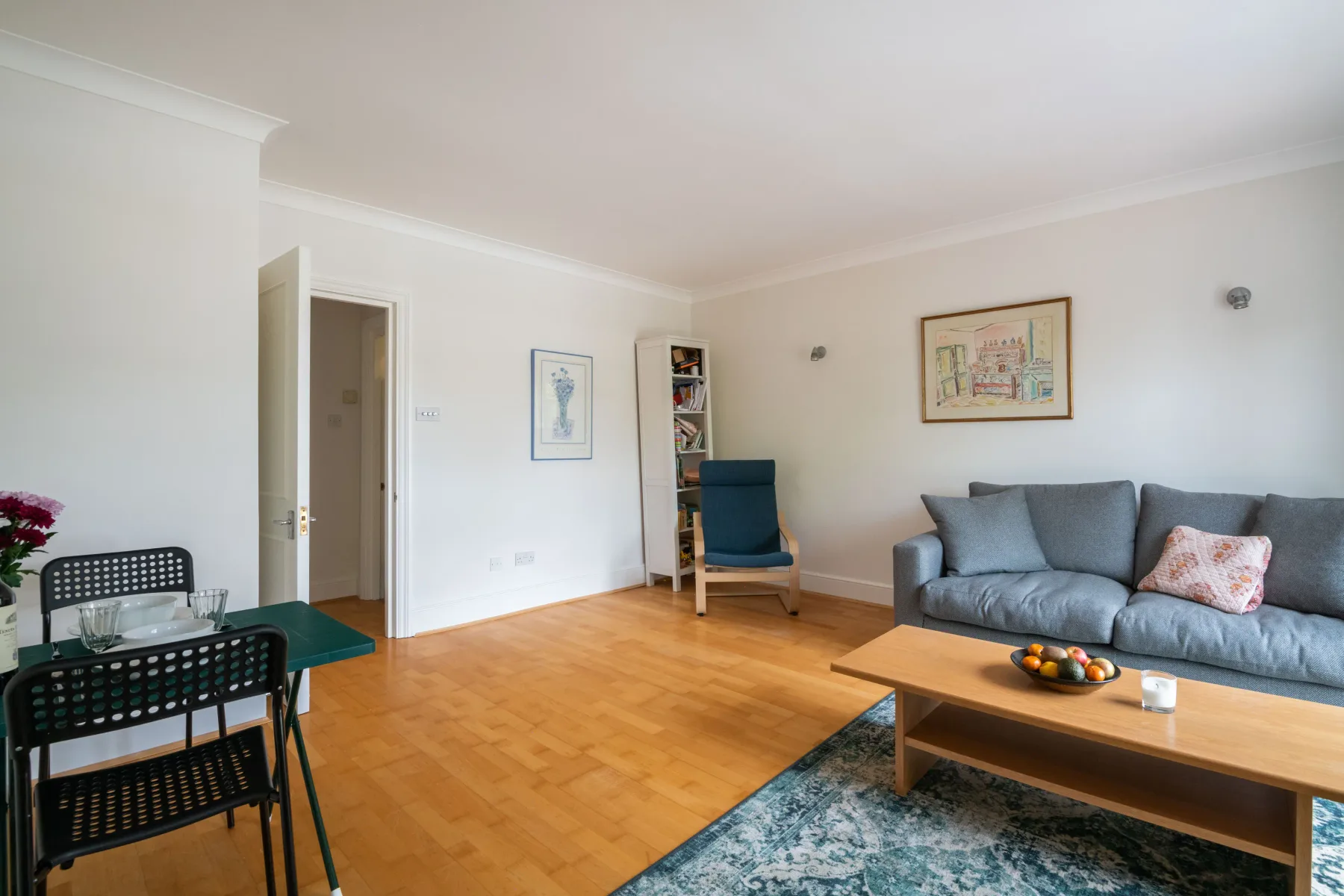 A living room with seating, a coffee table, and framed artwork.