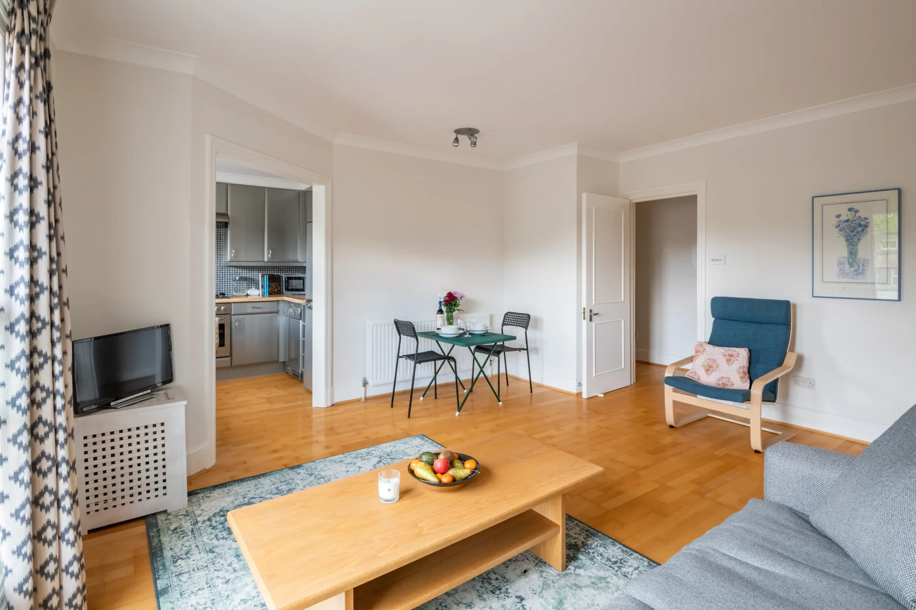 A bright living room with seating, a coffee table, and a dining area.