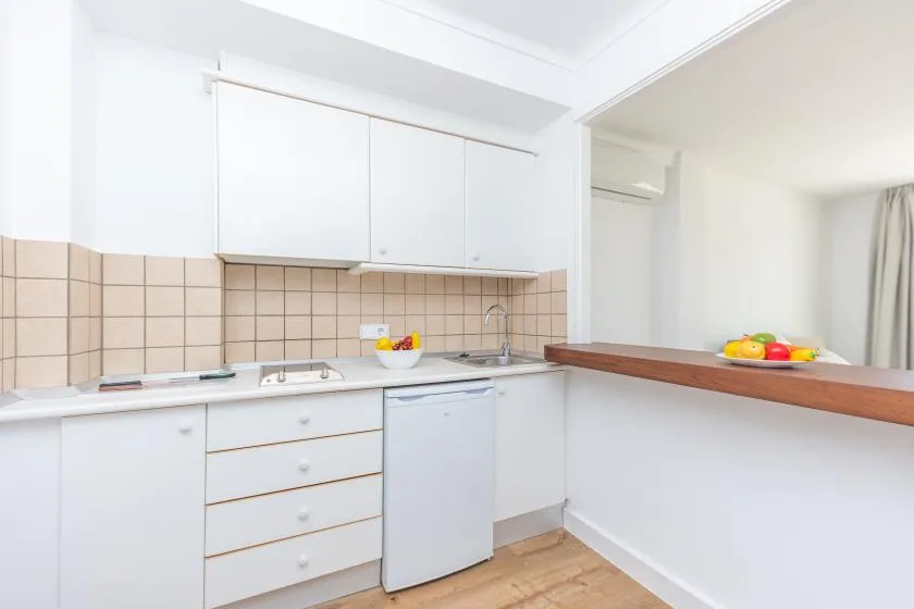 A bright kitchen with white cabinets, a countertop, and a breakfast bar.