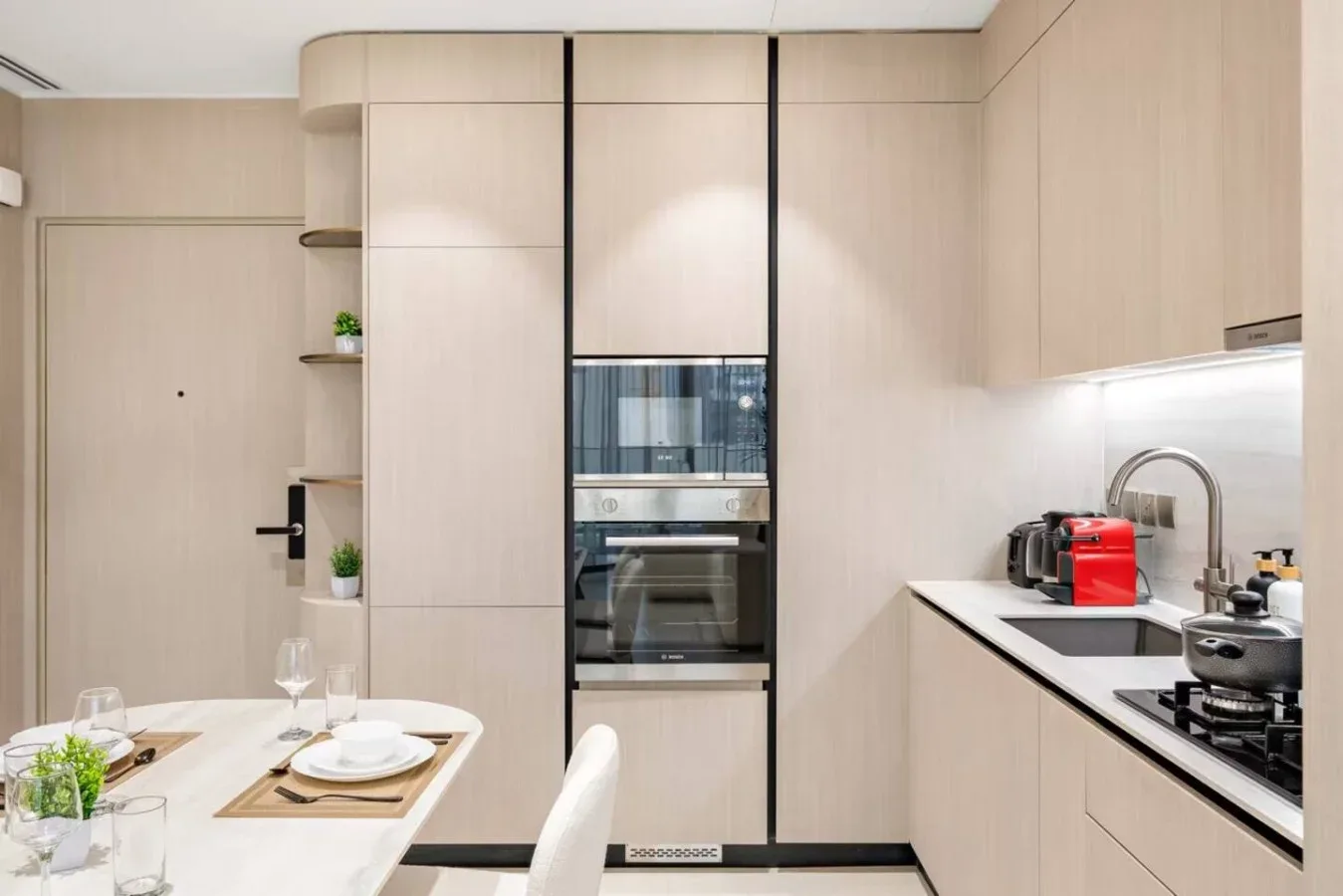 Una cocina moderna con electrodomésticos empotrados y una mesa de comedor.