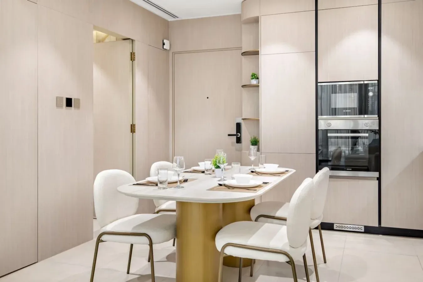 Comedor con la mesa puesta junto a una cocina integrada.