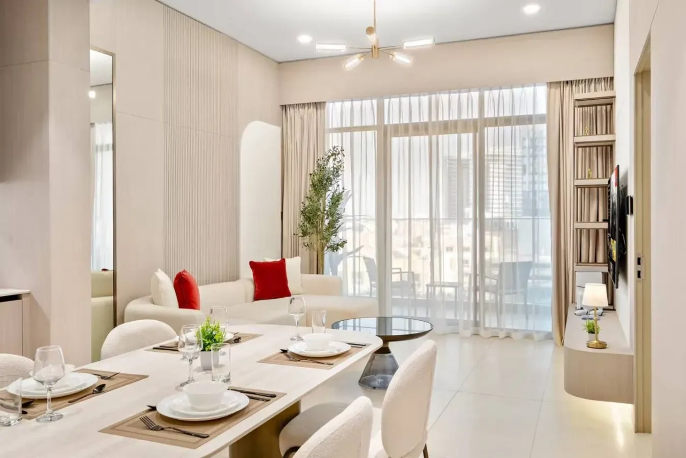 Una luminosa sala de estar y comedor con grandes ventanales y una mesa puesta.