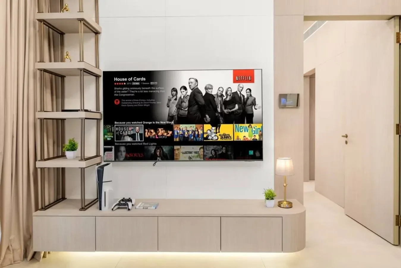 Una pared multimedia en una sala de estar tiene un televisor sobre un mueble bajo.