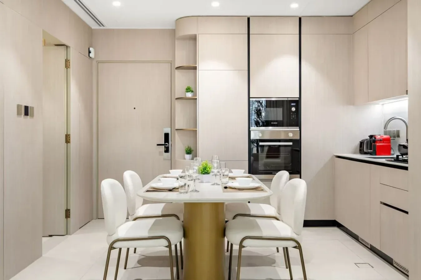 Un comedor con una mesa y asientos junto a armarios de cocina empotrados.