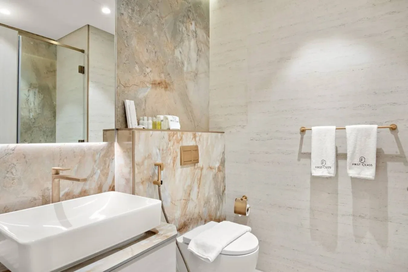Un baño luminoso con lavabo, inodoro y ducha de vidrio.