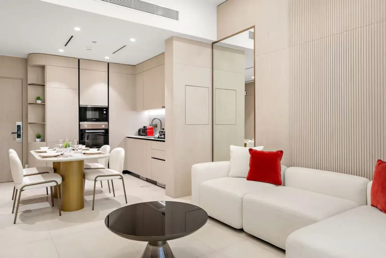 Una luminosa sala de estar y comedor diáfana, con un sofá blanco y una mesa de comedor.