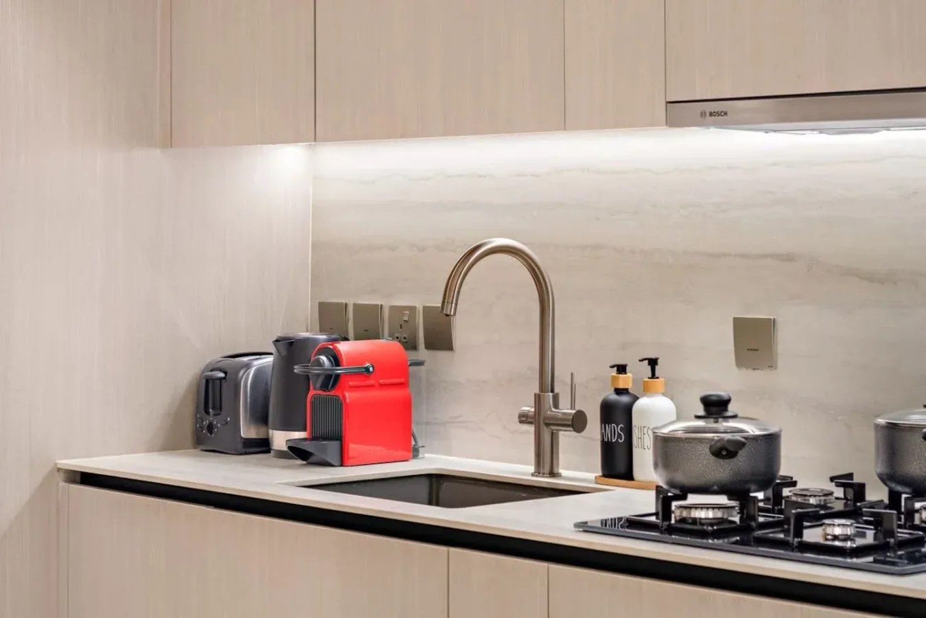 Una encimera de cocina moderna con fregadero, electrodomésticos y cocina de gas.