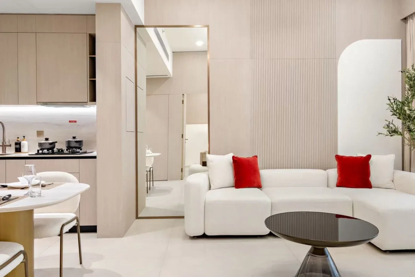 Una sala luminosa con asientos blancos y un comedor junto a la cocina.